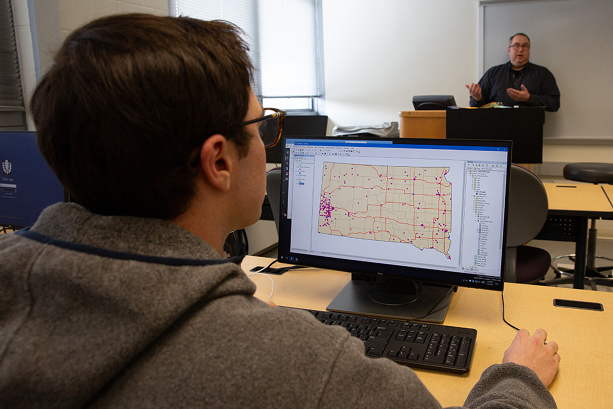 Students looks at map on computer during GEOG 2505: Applications of Geographic Information Systems.